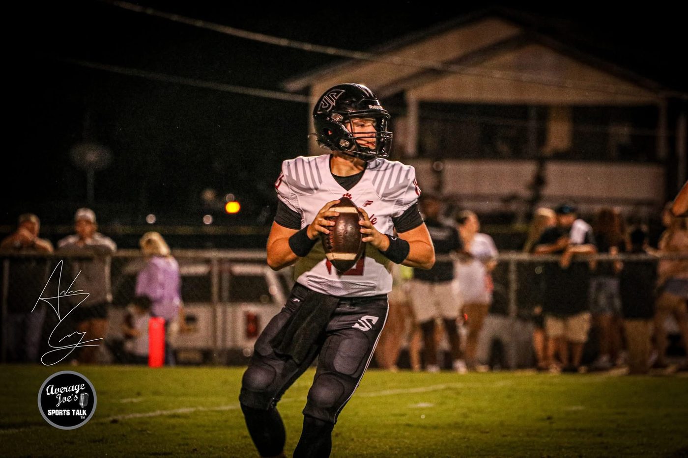 Panther quarterback dropping back to pass under the Friday night lights